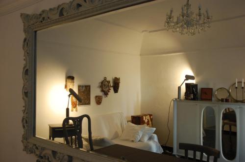 a mirror in a room with a bed and a lamp at Virginias B&B in Savona