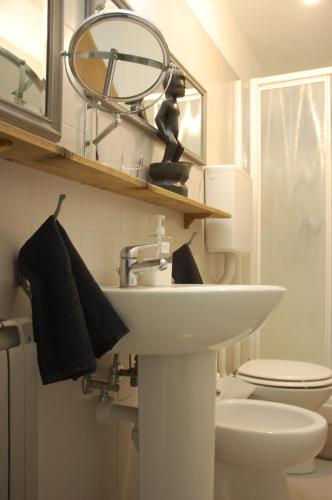a bathroom with a sink and a toilet and a mirror at Virginias B&B in Savona