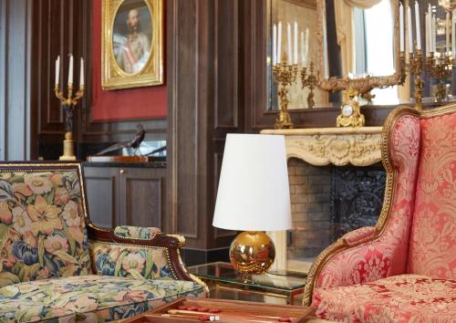 a living room with a chair and a fireplace at Living Hotel an der Oper in Vienna