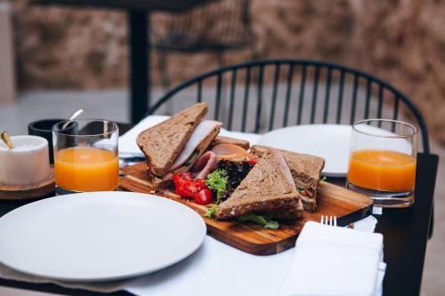 a table with a sandwich and two glasses of orange juice at Monastery Estate Venetian Harbor in Chania Town