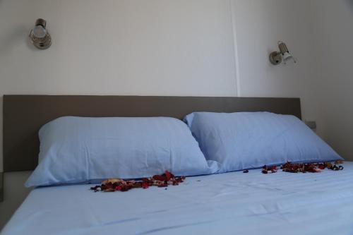 a bed with two pillows and some flowers on it at Camping Cisano - San Vito in Bardolino