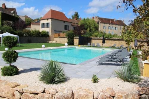a swimming pool with lounge chairs and a house at Hôtel du Lion d'OR in Charolles