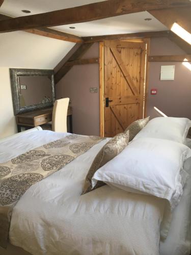 a bedroom with a bed and a wooden door at The Old Malt Scoop Inn in Lapford
