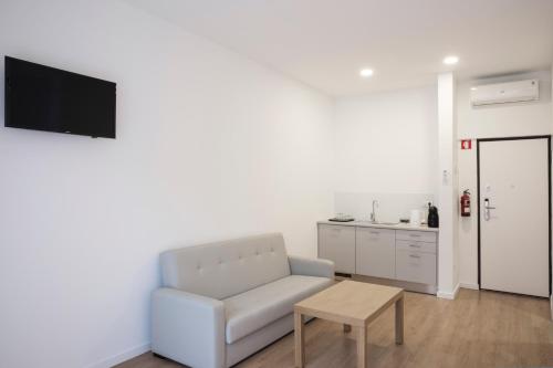 a white living room with a couch and a table at Porto Bonjardim Apartments in Porto