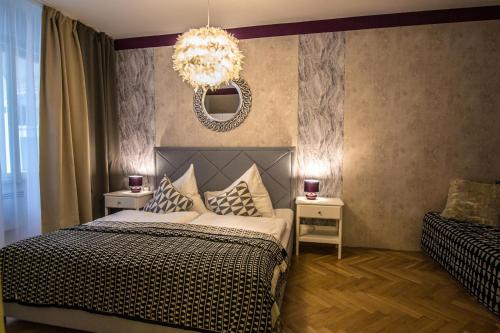 um quarto com uma cama e um lustre em Unique Apt 250m from the Charles Bridge em Praga