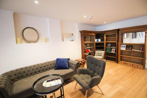 a living room with a couch and two chairs at das kleine Hotel in München in Munich