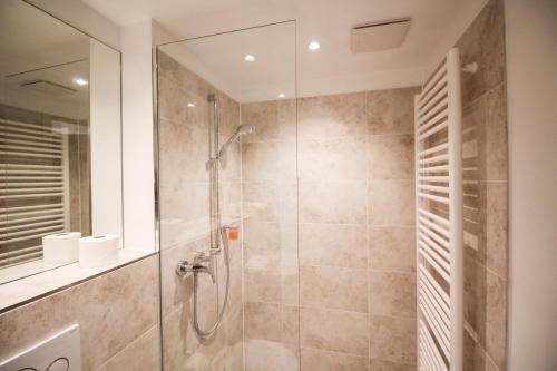 a bathroom with a shower with a glass door at das kleine Hotel in München in Munich