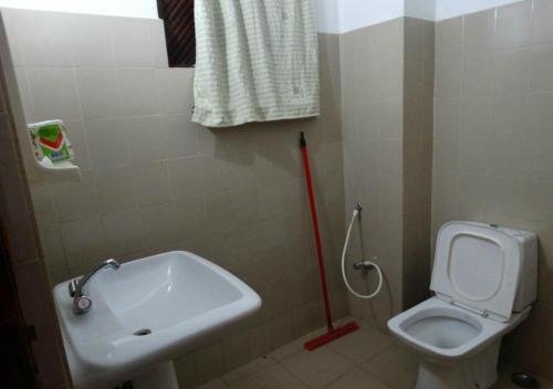 y baño con aseo blanco y lavamanos. en Majestic Tourist Hotel, en Kandy