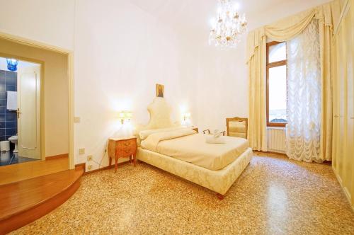 sypialnia z dużym łóżkiem i żyrandolem w obiekcie DolceVita Apartments N 287 w Wenecji