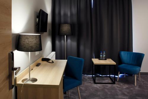 a room with a desk and two blue chairs at Czarny Staw in Aleksandrów Łódzki