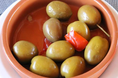 an orange bowl of soup with green olives at Casa Rural Luna in Candeleda
