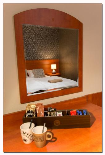 a bedroom with a large mirror above a bed at B&B Brasserie Lakerhof in Ohé en Laak