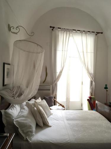 a bedroom with a large white bed with a window at Casa Letizia Amalfi Coast in Atrani