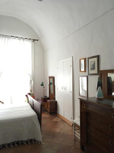 a bedroom with a bed and a dresser and a window at Casa Letizia Amalfi Coast in Atrani