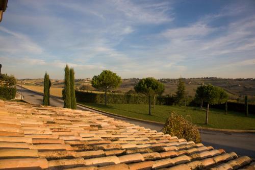 a stone wall next to a road with trees at Osteria dei Segreti in Appignano