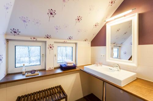 a bathroom with a sink and flowers on the ceiling at Lotsenhaus in Schülp