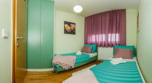 a room with two beds and a window at Ella Apartman Zagreb in Zagreb