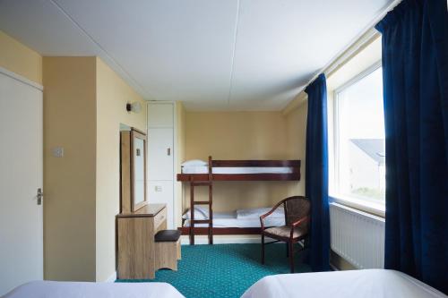 a small room with a bunk bed and a desk at Atlantic Apartotel in Bundoran