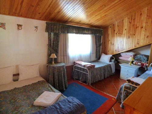 Una sala de estar con una cama y una ventana. en Casa Na Montanha Da Neve, en Seia