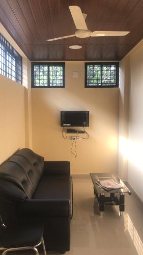 a living room with a couch and a table at SUPREME LODGe in Dharmastala