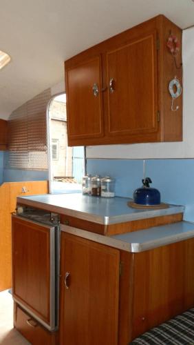 a kitchen with wooden cabinets and a counter top at Mousley House Farm Campsite and Glamping in Warwick