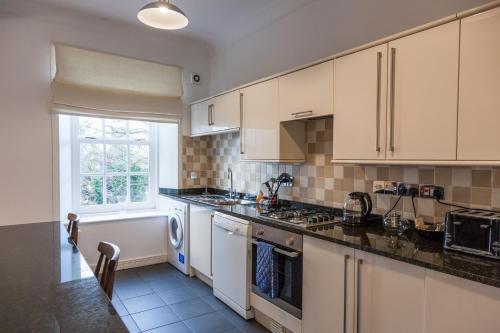 uma cozinha com armários brancos e uma janela em Apartment 3 The Grove em Durham