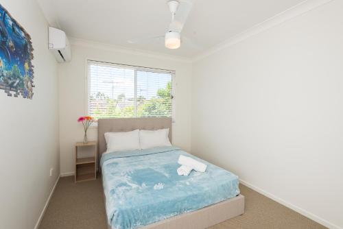 a bedroom with a bed with a blue blanket at Close Mountain Ocean Pet Friendly Eerlier Check in in Buderim