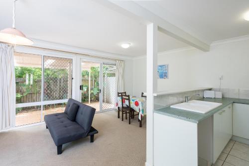 a kitchen and living room with a chair and a table at Close Mountain Ocean Pet Friendly Eerlier Check in in Buderim