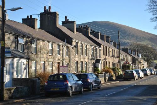 a row of cars parked on the side of a street at Tylwyth in Waenfawr