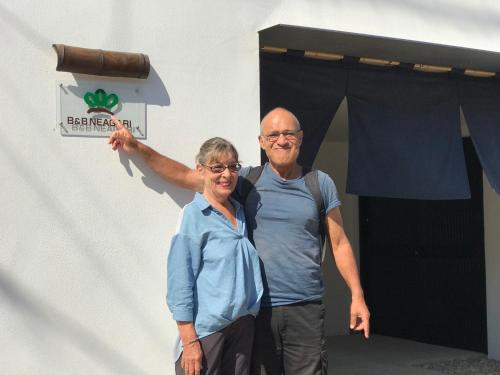 a man and a woman standing in front of a door at B&B Neagari in Nomi