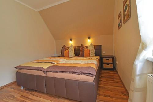 a bedroom with a large bed with orange pillows at Ferienwohnungen Schön in Teltow