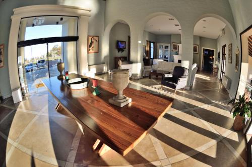 una gran sala de estar con una mesa de madera en el centro en Hotel Santa Cristina, en Durazno