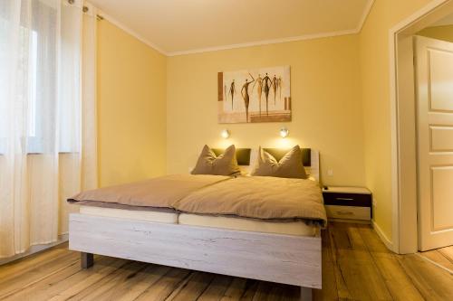 a bedroom with a large bed with yellow walls at Ferienwohnungen Schön in Teltow