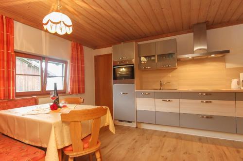 a kitchen with a table and a dining room at Mosshamhof in Saalfelden am Steinernen Meer