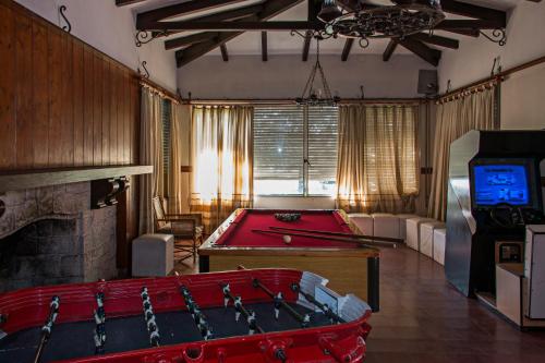 un soggiorno con tavolo da biliardo e TV di Hotel Parque Siquiman a Villa Carlos Paz