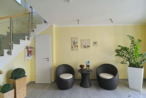 a living room with two chairs and a staircase at Ferienwohnungen Schön in Teltow