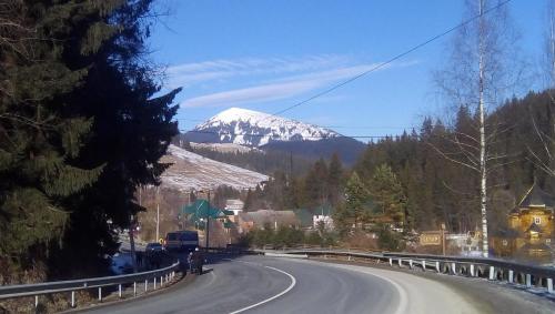 a road with a snow covered mountain in the background at Яблуневий сад in Yablunytsya