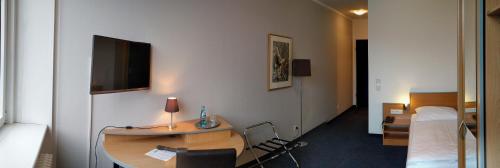 a hotel room with a desk and a bed at Hotel Sedes in Berlin