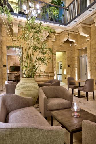 a lobby with chairs and a vase with a plant at 66 Saint Paul's & Spa in Valletta
