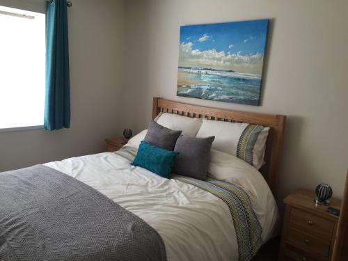 a bedroom with a bed with a painting on the wall at Yr Hafan in Trelech