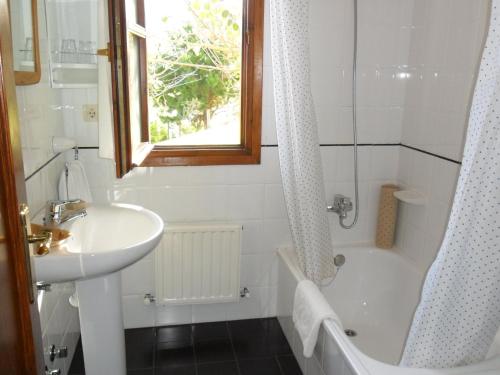W łazience znajduje się umywalka, wanna i prysznic. w obiekcie Hotel La Llosona w mieście Ribadesella