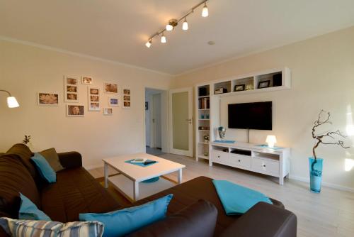 a living room with a couch and a tv at Ferienwohnungen Schön in Teltow