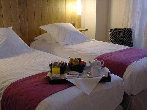 穆瓦薩克的住宿－船主酒店，一张盛放食物和饮料的托盘,放在两张床上