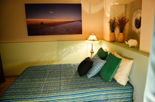 a bedroom with a bed with pillows and a lamp at Magic Garden House in Cali
