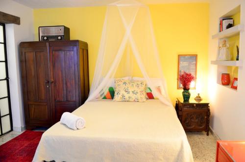 a bedroom with a white bed with a canopy at Magic Garden House in Cali