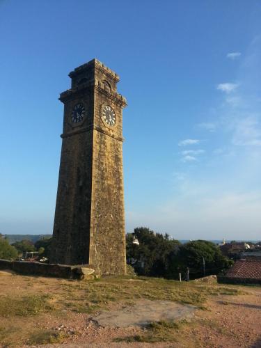 a clock tower in the middle of a field at Old Parkland Hostel in Galle