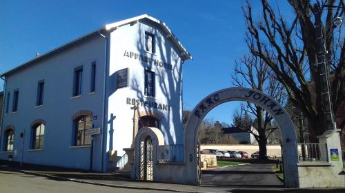 a white building with an archway in front of it at Appart'Hotel Parc Johan in Chauffailles