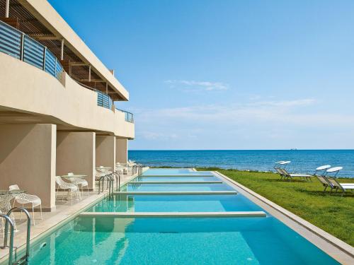 una piscina del complejo con el océano en el fondo en Grecotel Astir Alexandroupolis, en Alexandroupoli