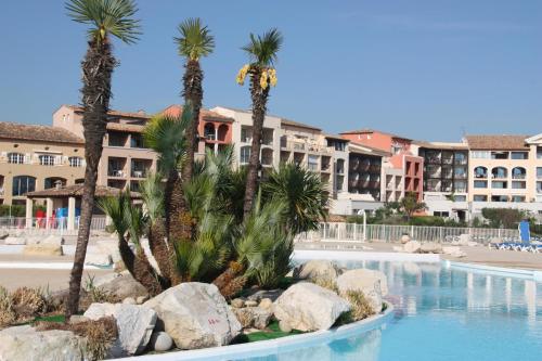 un complexe avec des palmiers et une piscine dans l'établissement Les Marines de Gassin, à Gassin