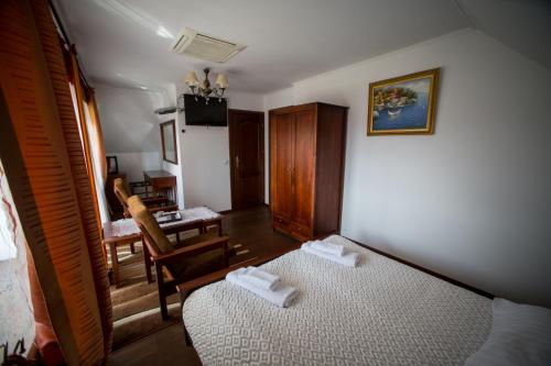 a room with two beds and a chair and a desk at Hotel & Spa Arkadia in Tomaszów Lubelski